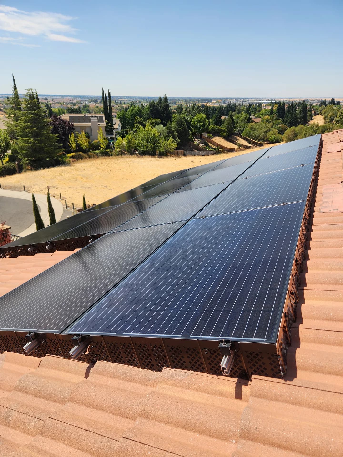 Critter-guard mesh installed around a rooftop solar array on barrel tile