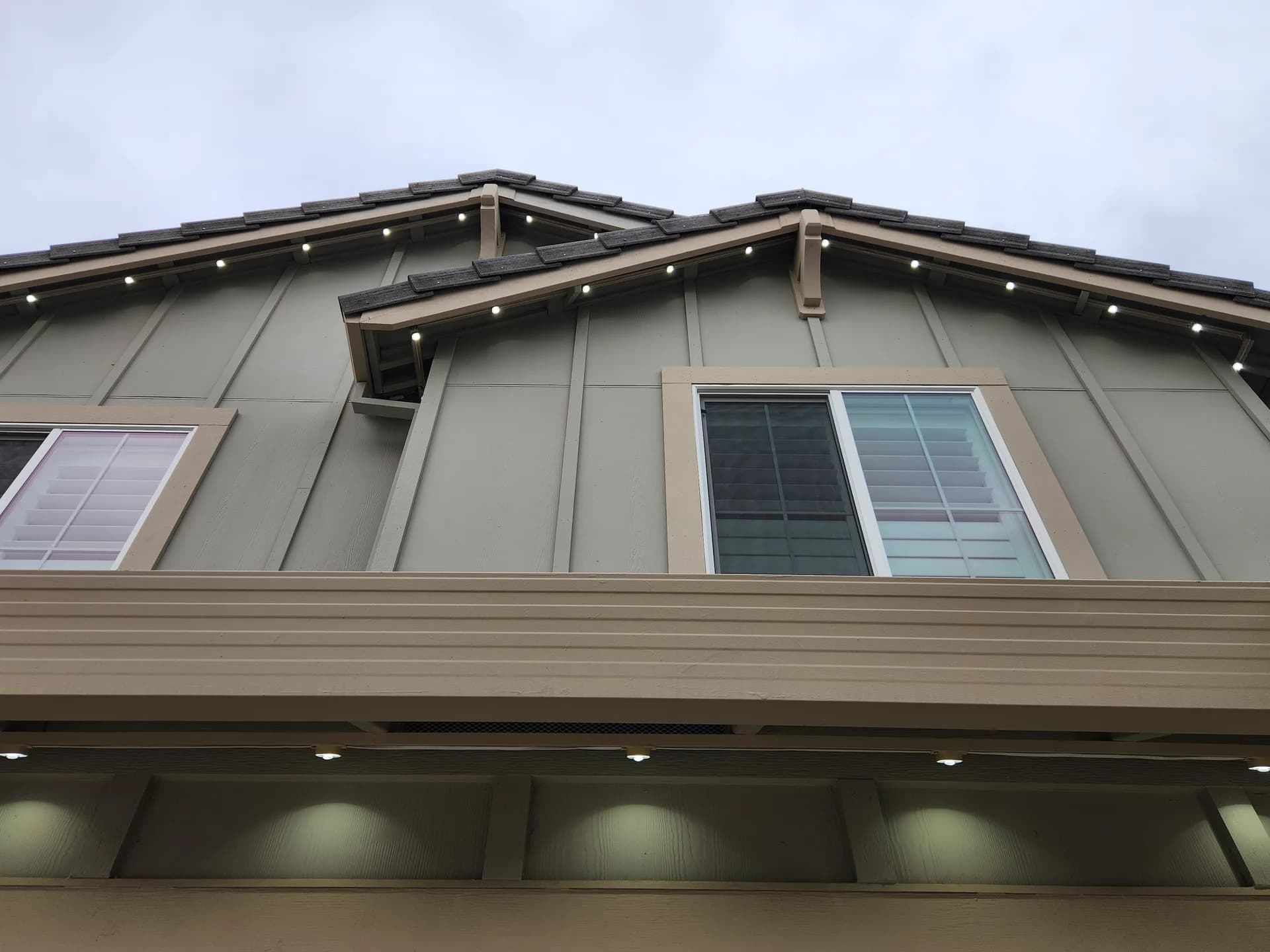 Low-profile permanent Christmas lights along gable fascia, discreet in daylight