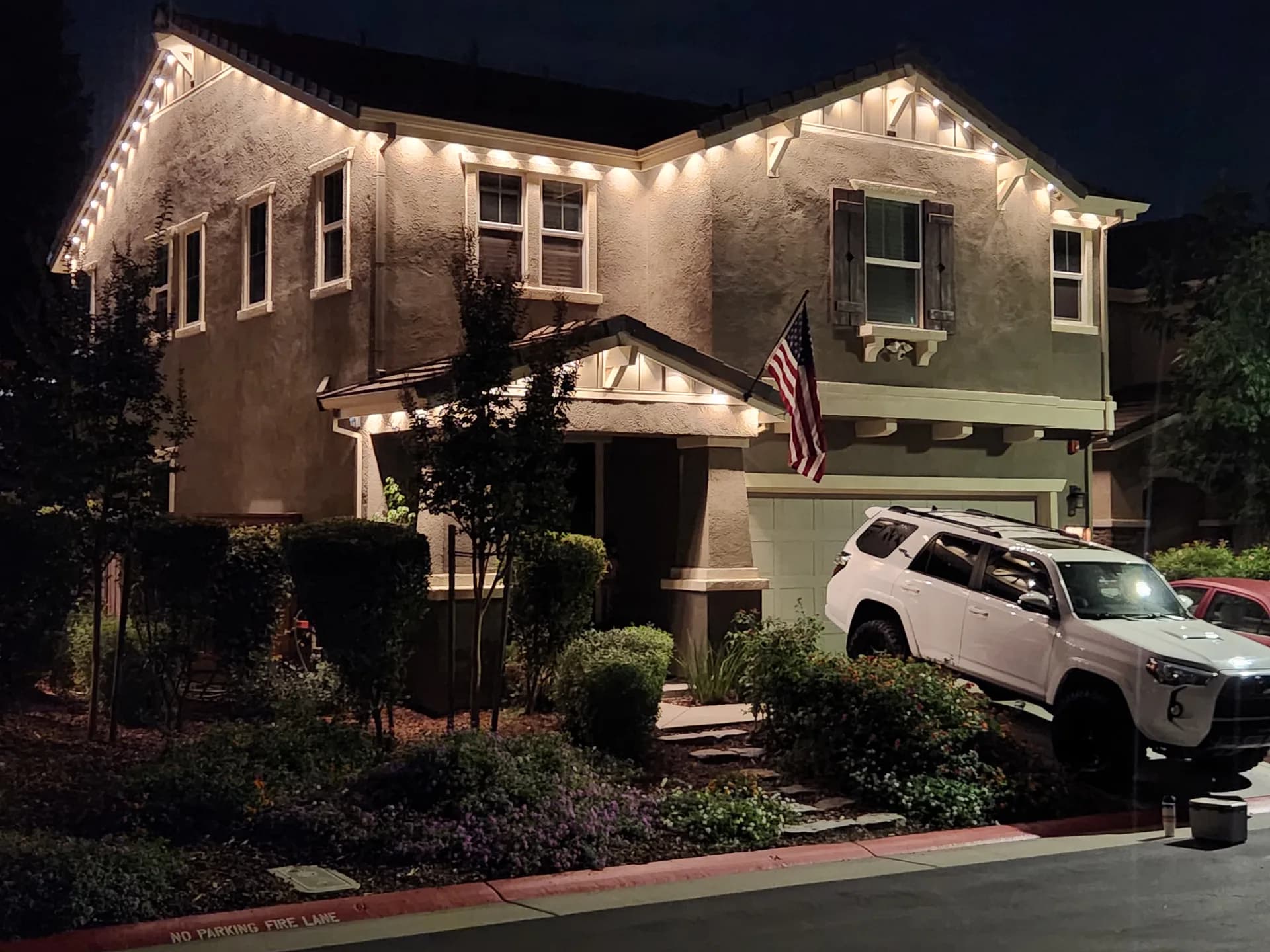 Permanent warm-white holiday lights on a two-story home in the Sacramento area