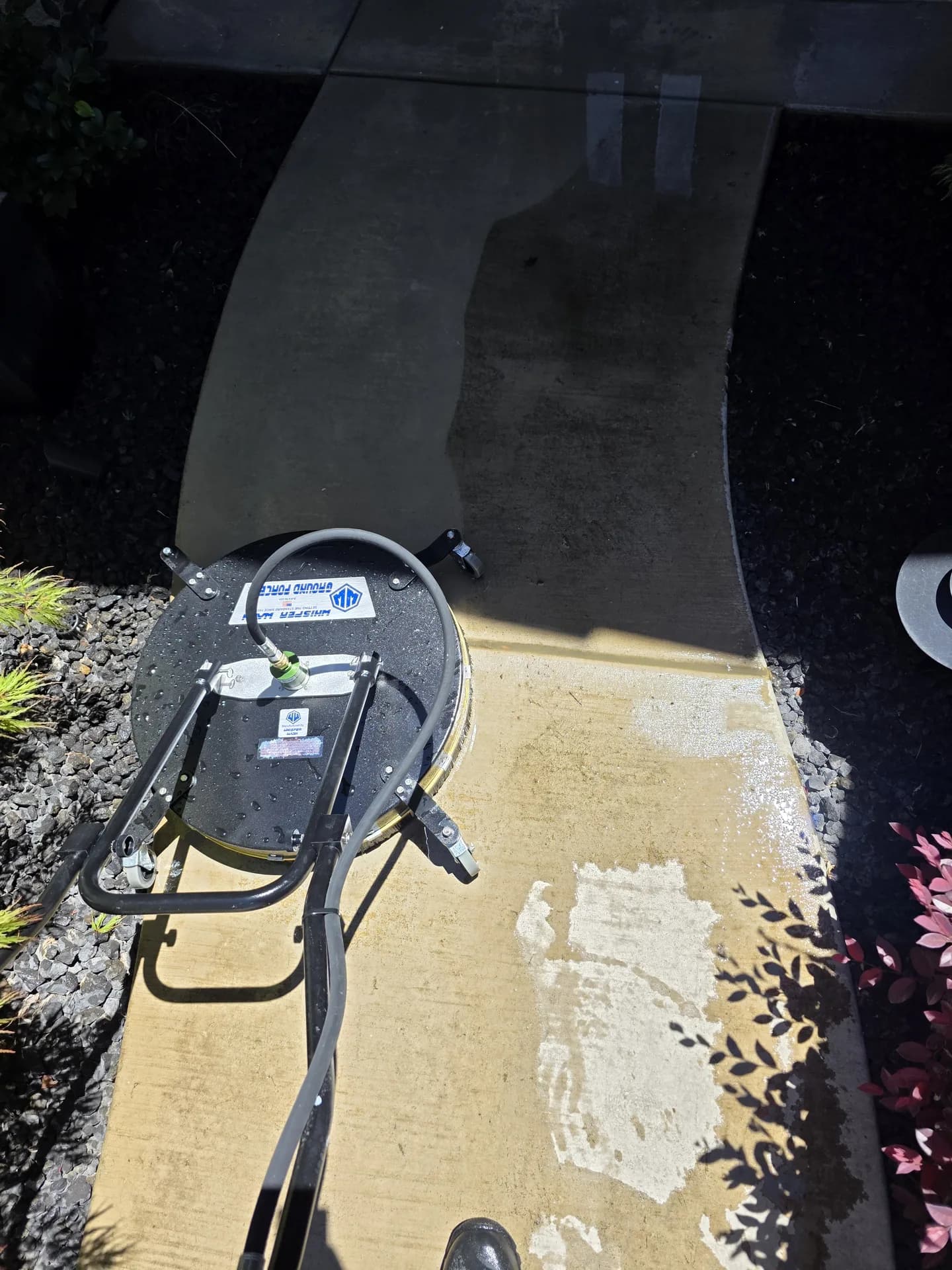 Pressure washing a concrete walkway with a surface cleaner, dirty and clean sides in one shot
