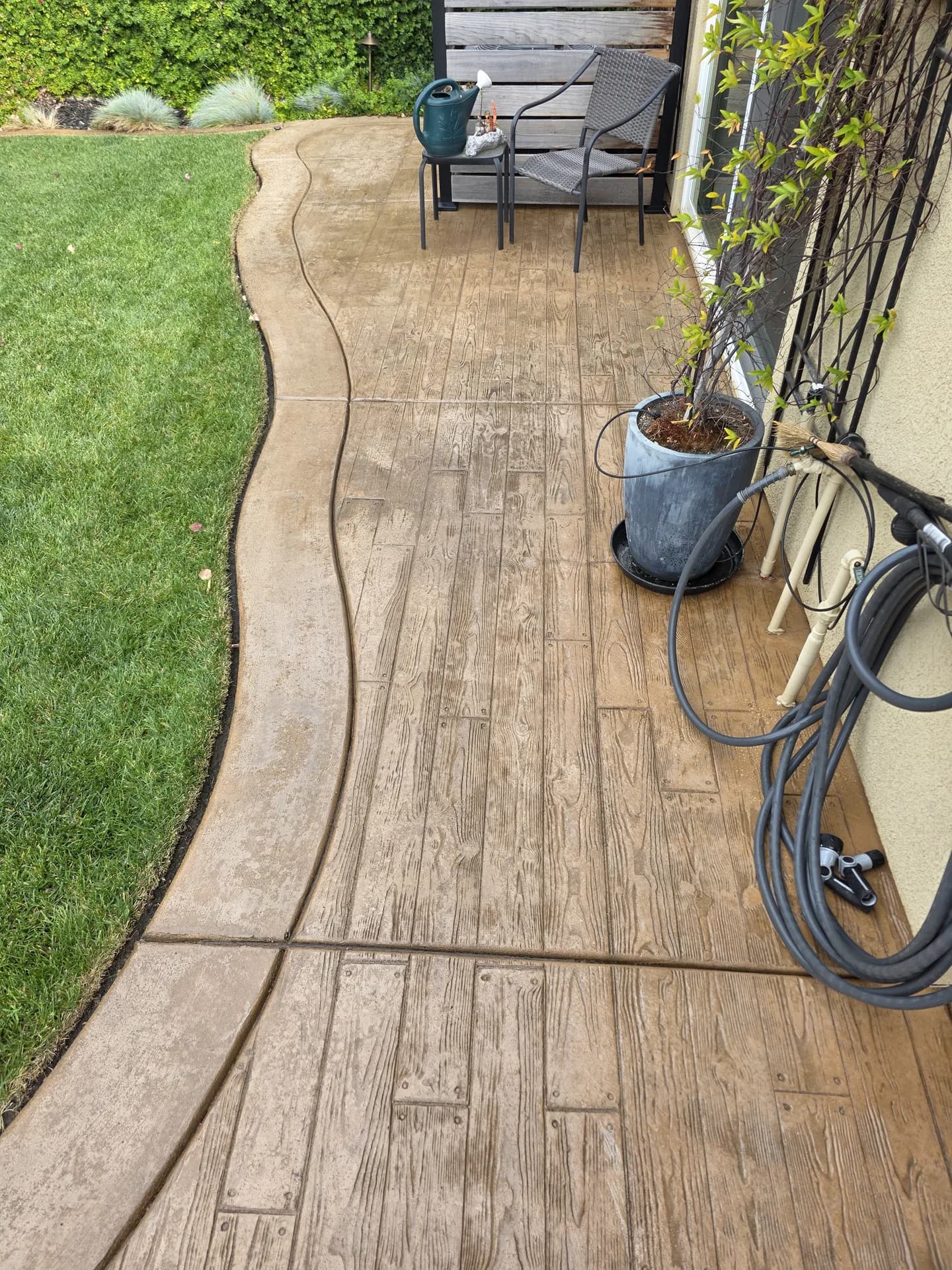 Stamped-concrete patio after pressure washing, wood-plank texture restored