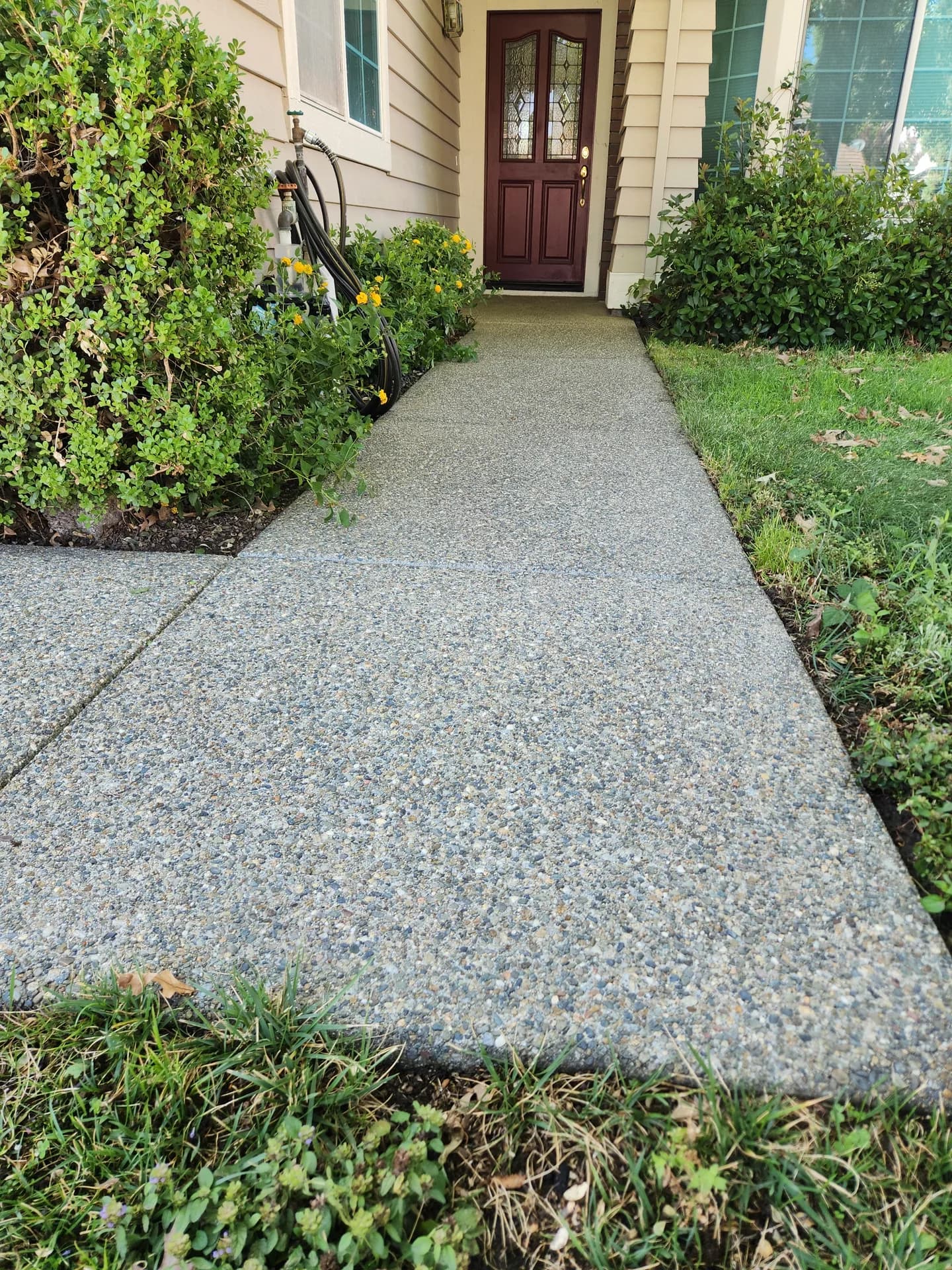 Pressure washed exposed-aggregate walkway to a Rocklin home, restored to a clean speckled finish